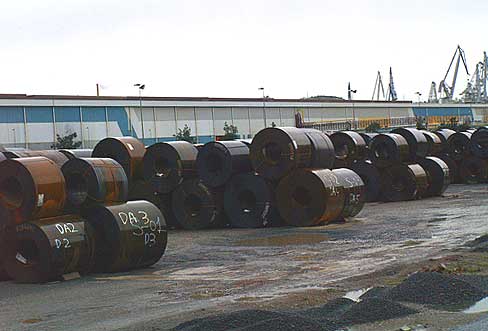 Bobinas de acero en Sestao, con la nave que alberga la acera al fondo.